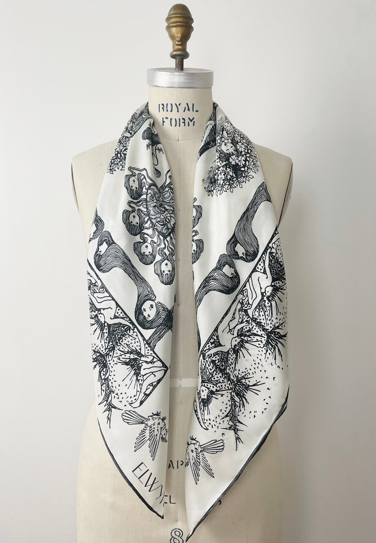 a luxury, bespoke Elwyn New York silk scarf wrapped around the neck of a form with black and white, art nouveau, whimsical, storybook print