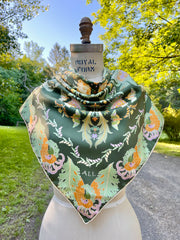 A dress form with an Italian silk scarf wrapped around the neck with an Art Nouveau print inspired featuring a kaleidoscope of fantastical flowers, butterflies and cockatoos rising from the curling foliage