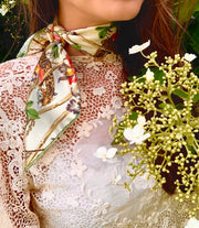 classic woman standing around hydrangeas wearing luxury, bespoke Elwyn New York silk bandana around her neck with vintage tropical, floral, bamboo, leopard wall paper print 