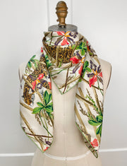 luxury, bespoke Elwyn New York silk scarf wrapped around the neck of a form with vintage tropical, floral, bamboo, leopard wall paper print