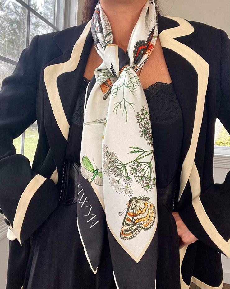 Classic woman wearing an elegant suit and a luxury, bespoke Elwyn New York silk scarf tied around her torso with a vintage style, botanical, floral, butterfly and leopard print