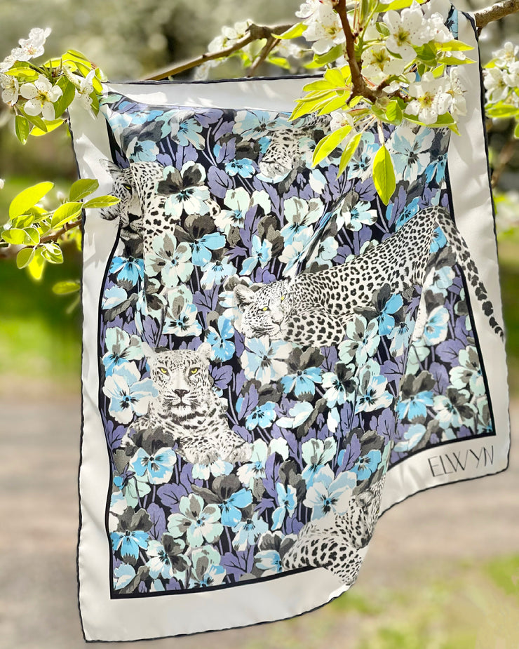 This bespoke, designer silk bandana is inspired by vintage allover floral prints.  The lazing, graphic leopards popping through a field of blue, mint and purple watercolor pansies add a modern appeal.