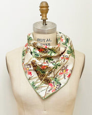 a  luxury, bespoke Elwyn New York silk bandana draped on a form like a bib with vintage tropical, floral, bamboo, leopard wall paper print