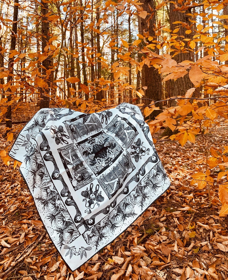 luxury, bespoke Elwyn New York silk bandana with black and white, art nouveau, whimsical, storybook print, hanging on a branch of orange fall leaves