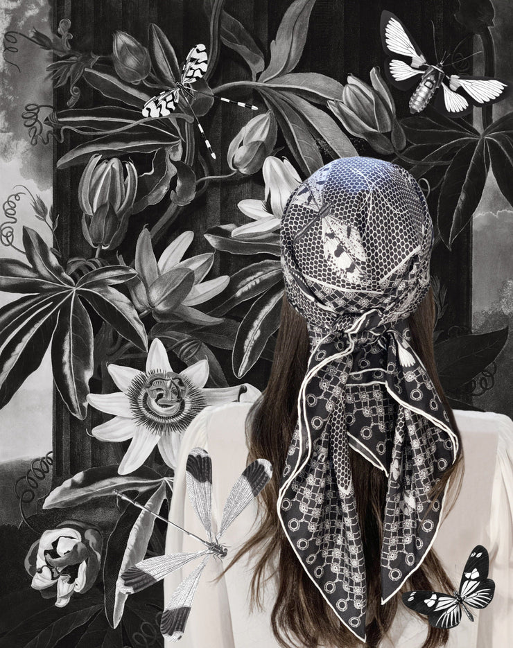 classic female surrounded by flora and butterflies wearing bespoke, luxury, black and white Elwyn New York silk scarf on her head with butterflies and vintage lace print