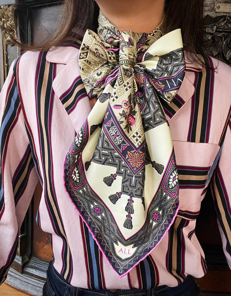 Classic Woman wearing a luxury silk scarf with a floral and geometric pattern around her neck. Perfect example of scarf styling.  Bespoke monogram detail can also be seen
