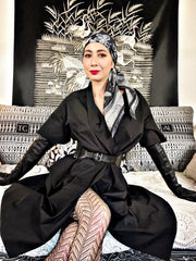 classic female wearing a belted black dress, tights, gloves and bespoke, luxury, black and white Elwyn New York silk scarf around her head with vintage lace print and graphic fringe border
