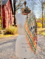 An Italian silk scarf with a Geometric Design, mixing earth tones and pops of brightly colored etymological butterflies tied around the neck of a dress form. 
