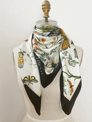 A luxury, bespoke Elwyn New York silk scarf wrapped around the neck of a form with a vintage style, botanical, floral, butterfly and leopard print
