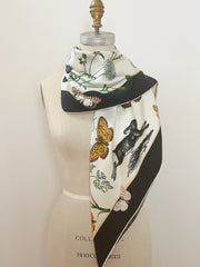 A luxury, bespoke Elwyn New York silk scarf wrapped around the neck of a form with a vintage style, botanical, floral, butterfly and leopard print