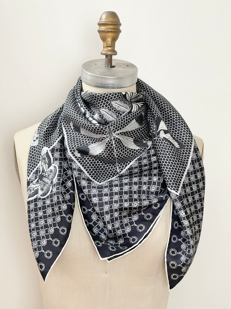 A bespoke luxury, black and white Elwyn New York silk scarf wrapped around the neck of a form with butterflies and vintage lace print