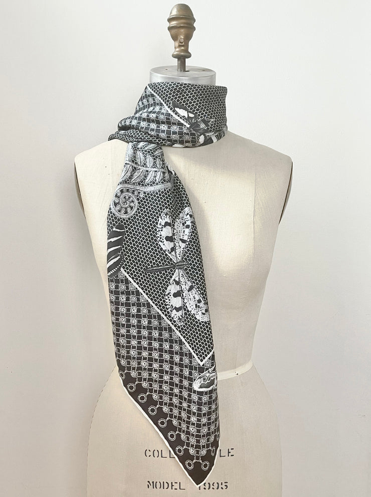 A bespoke luxury, black and white Elwyn New York silk scarf wrapped around the neck of a form with butterflies and vintage lace print