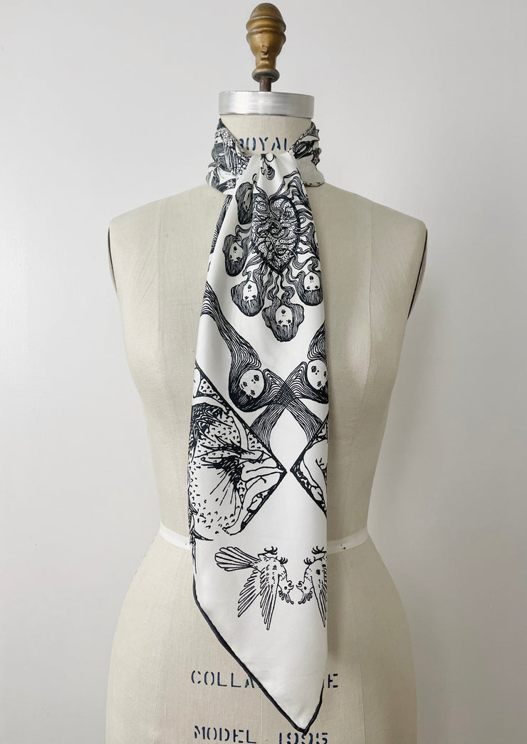 a luxury, bespoke Elwyn New York silk scarf knotted at the neck of a form with black and white, art nouveau, whimsical, storybook print