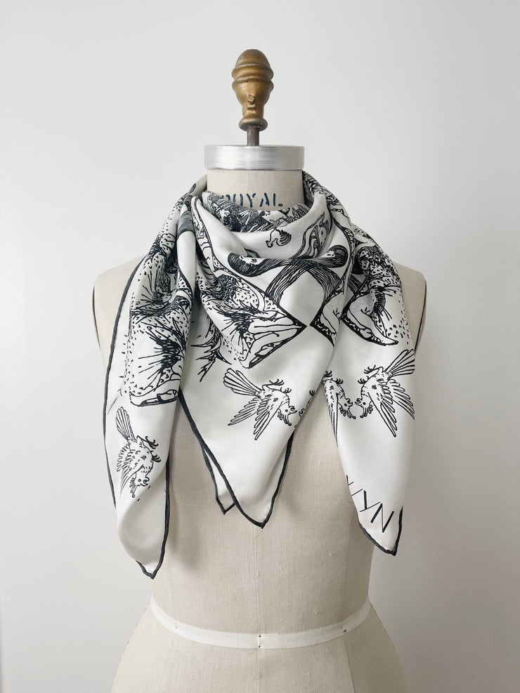 a luxury, bespoke Elwyn New York silk scarf wrapped twice around the neck of a form with black and white, art nouveau, whimsical, storybook print