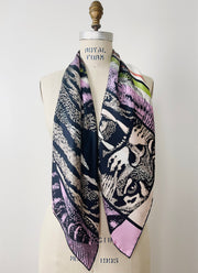 A luxury, bespoke Elwyn New York silk scarf hanging around the neck of a form with a fierce tiger and pastel lavender, peach, green, black stripe print