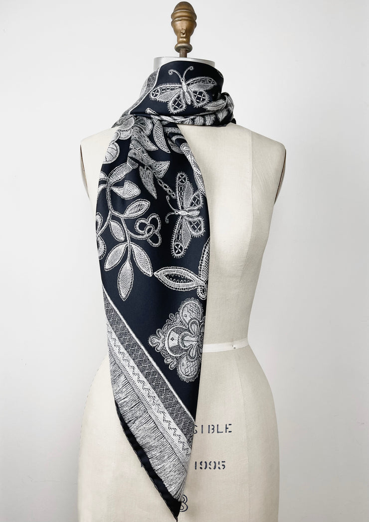 bespoke, luxury, black and white Elwyn New York silk scarf wrapped around the neck of a form with vintage lace print and graphic fringe border