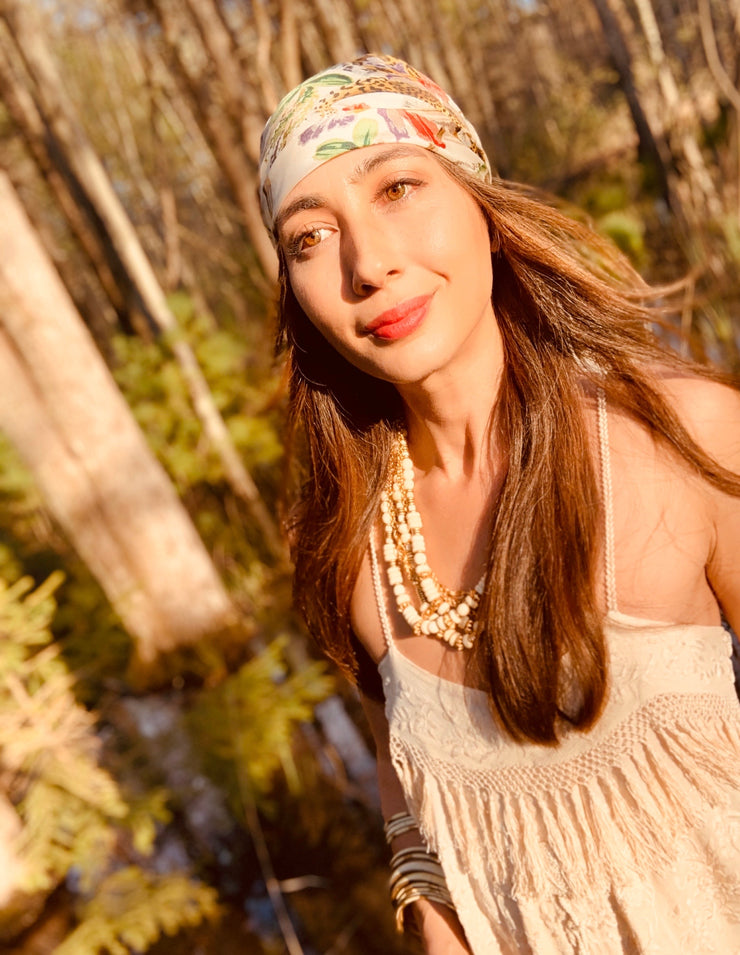 Front View of a classic woman in the middle of the woods, wearing a luxury, bespoke Elwyn New York silk scarf on her head with vintage tropical, floral, bamboo, leopard wall paper print