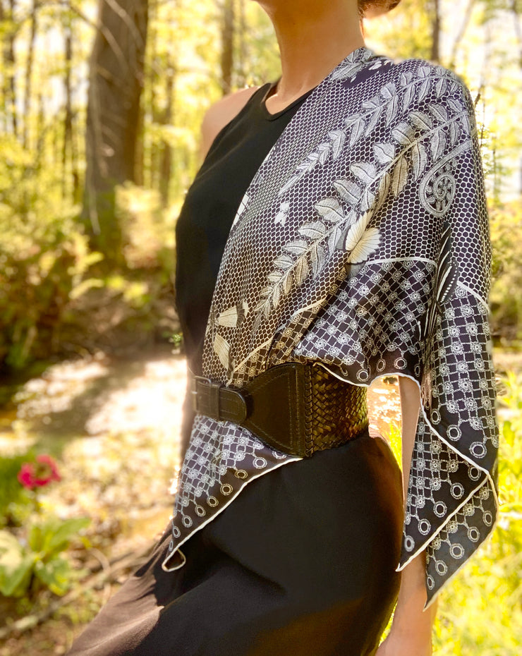 classic woman in the middle of the forest wearing bespoke, luxury, black and white Elwyn New York silk scarf around her neck with butterflies and vintage lace print draped on her shoulder and belted 