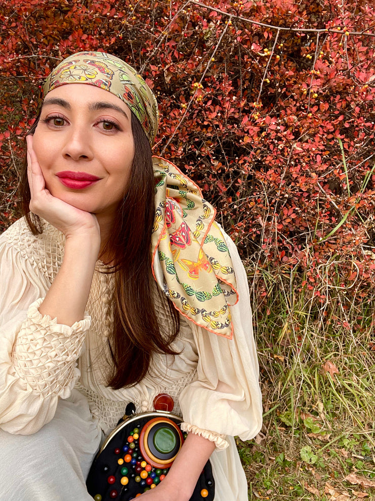 Model wearing an aztec butterfly silk scarf around her head and a vintage clutch and vintage dress. Headscarf love