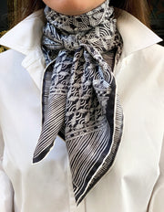 Classic woman wearing a luxury, bespoke, black and white Elwyn New York silk scarf tied around her neck with vintage modern style graphic needlework and crochet print