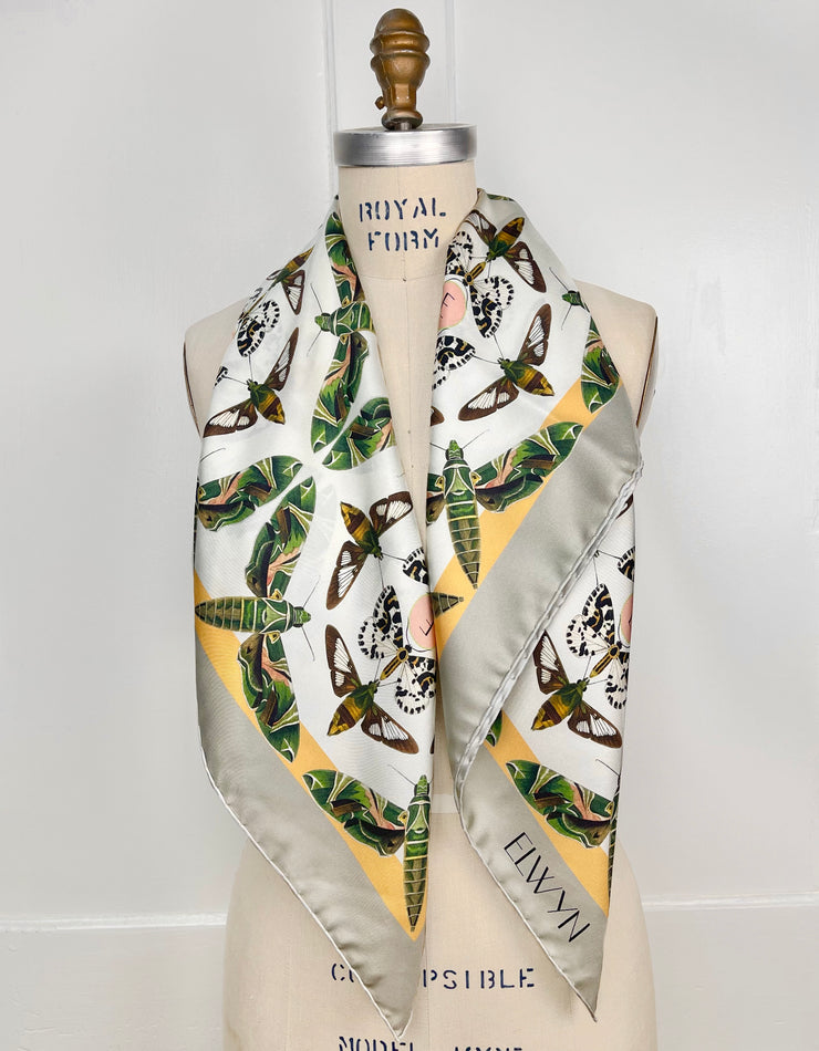 Front view of a luxury, bespoke Elwyn New York silk scarf wrapped around the neck of a form with a geometric butterfly vintage modern style print