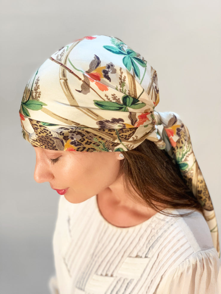 side view of a classic woman wearing a luxury, bespoke Elwyn New York silk scarf on her head with vintage tropical, floral, bamboo, leopard wall paper print 