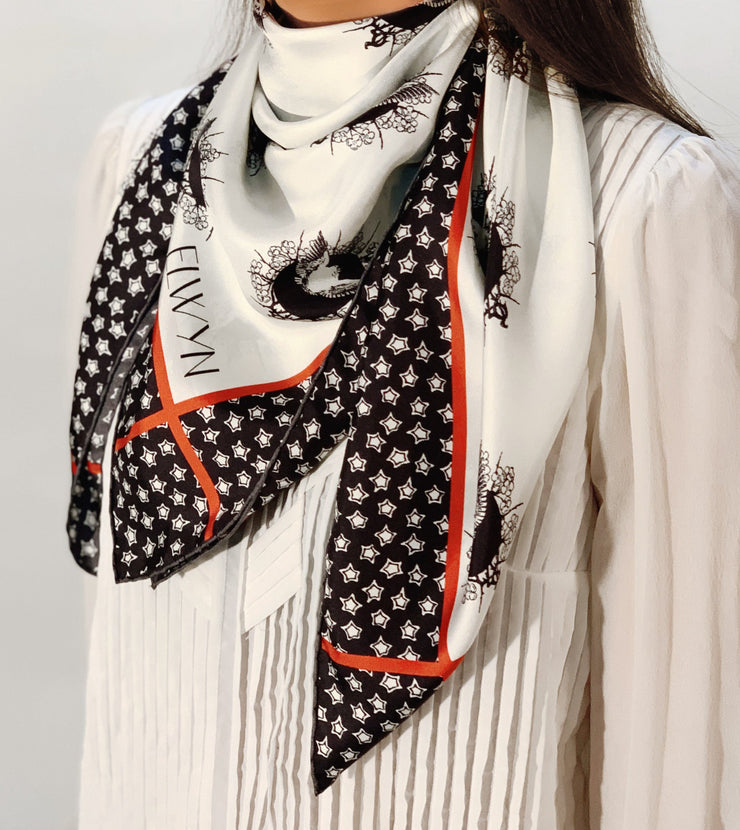 side view of classic woman wearing a luxury, bespoke Elwyn New York silk scarf around her neck with black and white, whimsical, polka dot, bird and stars, storybook print