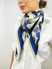 Side view of a classic woman wearing a bespoke, luxury elwyn new york scarf looped around her neck. This Denim friendly, zig-zag, art deco floral print feels modern and graphic.