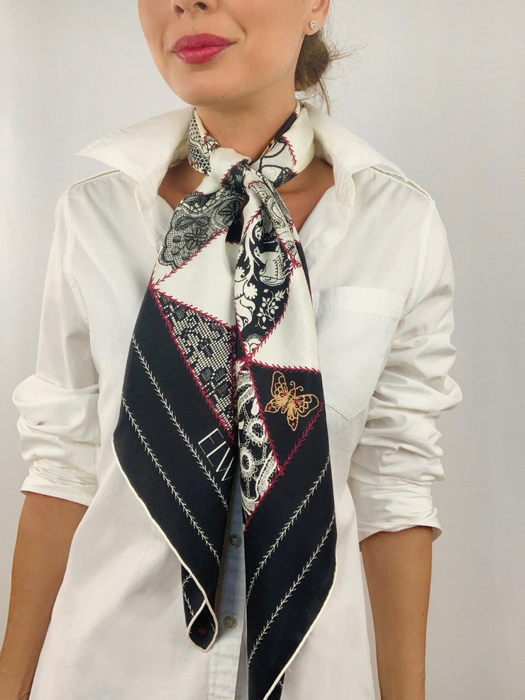Classic woman wearing bespoke, luxury Elwyn New York silk scarf tied long  around her neck. This geometric crazy quilt print is a vintage-modern depiction of the year 2020 filled with digital embroidery and lace of years past