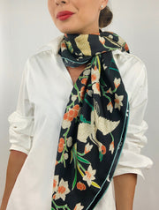 Classic woman wearing bespoke Elwyn New York Scarf draped loose and long around her neck with a botanical crane print is collaged together from antique glass and pearl, beaded embroideries of yesteryear.