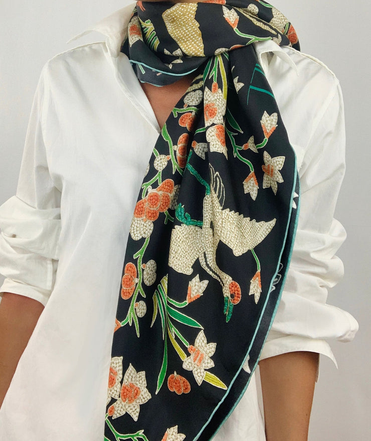Classic woman wearing bespoke Elwyn New York Scarf draped loose and long around her neck with a botanical crane print is collaged together from antique glass and pearl, beaded embroideries of yesteryear.
