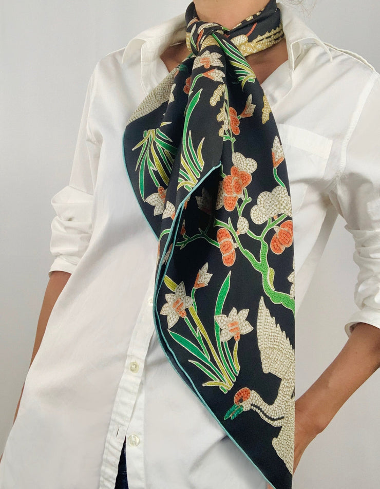 Classic woman wearing bespoke Elwyn New York Scarf tied long around her neck with a botanical crane print is collaged together from antique glass and pearl, beaded embroideries of yesteryear.