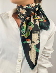 Classic woman wearing bespoke Elwyn New York Scarf tied  around her neck with a botanical crane print is collaged together from antique glass and pearl, beaded embroideries of yesteryear.