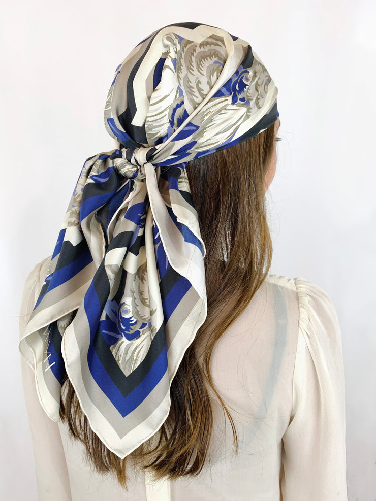 Back view of a classic woman wearing a bespoke, luxury elwyn new york scarf on her head. This Denim friendly, zig-zag, art deco floral print feels modern and graphic.