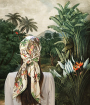 classic female standing in a fantastical, illustrated lush frond Jungle in Vietnam wearing luxury, bespoke Elwyn New York silk scarf on her head with vintage tropical, floral, bamboo, leopard wall paper print 