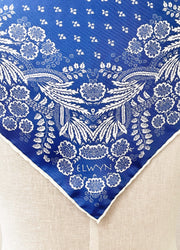 Closeup photo of a bespoke Elwyn New York Scarf with an ornate, blue and white, vintage-pastoral bandana design. Classic, feminine, and romantic with an example pf customer's initials on it