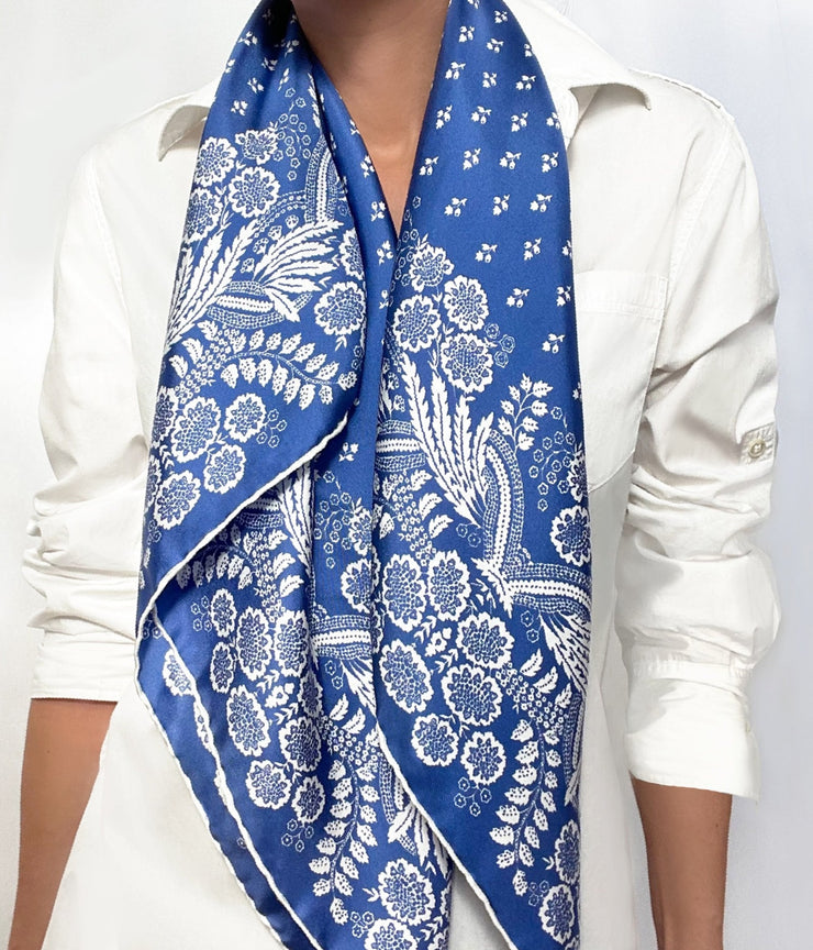 Woman wearing a personalized bespoke Elwyn New York Scarf draped around her neck with an ornate, blue and white, vintage-pastoral bandana design. Classic, feminine, and romantic