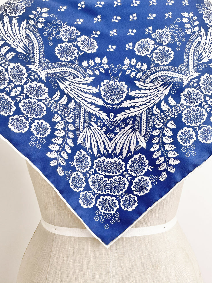 Closeup photo of a personalized bespoke Elwyn New York Scarf with an ornate, blue and white, vintage-pastoral bandana design. Classic, feminine, and romantic with an example pf customer's initials on it