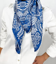 Woman wearing a personalized bespoke Elwyn New York Scarf around her neck with an ornate, blue and white, vintage-pastoral bandana design. Classic, feminine, and romantic
