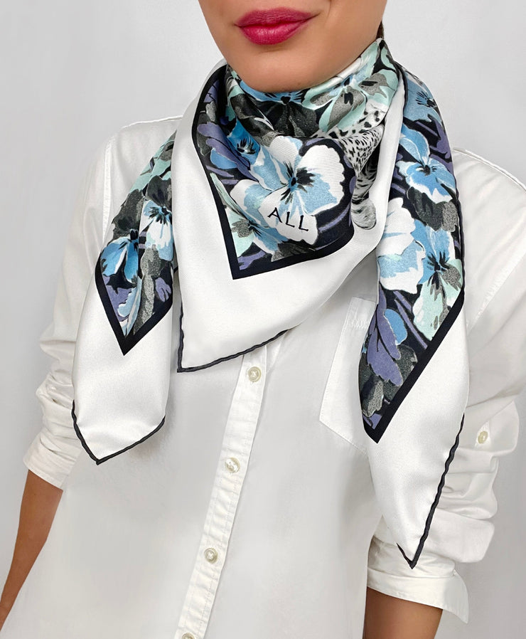 Classic woman wearing a luxury, bespoke Elwyn New York silk scarf around her neck with vintage style print of floral field and modern lazing leopards