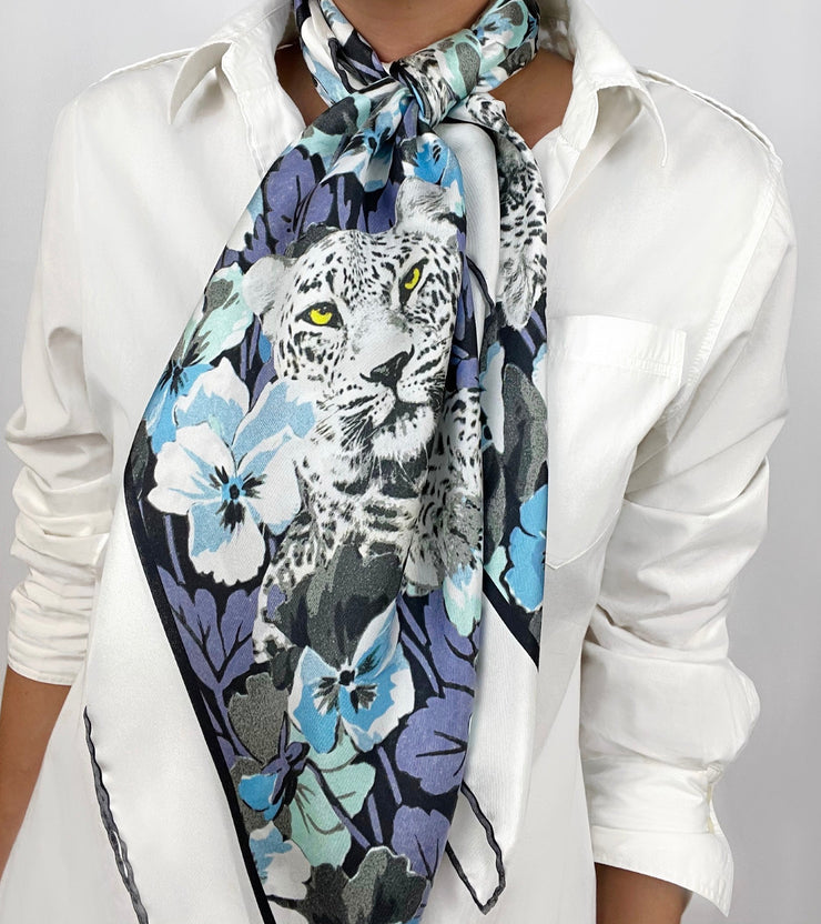 Classic woman wearing a luxury, bespoke Elwyn New York silk scarf tied long and loose around her neck with vintage style print of floral field and modern lazing leopards