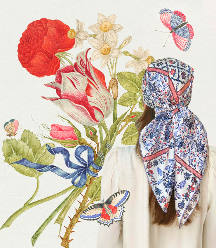 Classic model wearing a silk scarf around her head. The main pattern is made up of a red, white and blue diamond lattice of curving ribbons, enclosing sprays of flowers and is surrounded by an eyelet lace border, adorned with charming little birds.