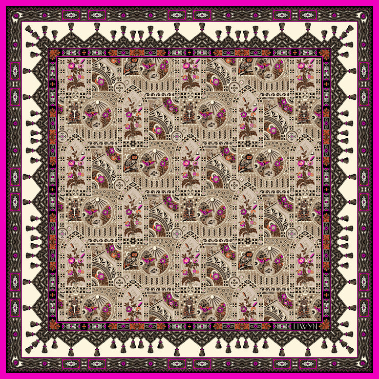 An Italian silk bandana featuring an Anglo-Japanesque print with intersecting geometric forms, framing little garden, owl and cat motifs, surrounded by a woven ribboned border and dangling tassels with pops of fuchsia and orange throughout. 