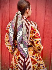 A classic model wearing a silk scarf tied around her hairwith a midnight garden print. 