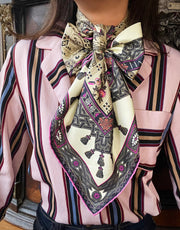 Classic Woman wearing a luxury silk scarf with a floral and geometric pattern around her neck.  Perfect example of scarf styling